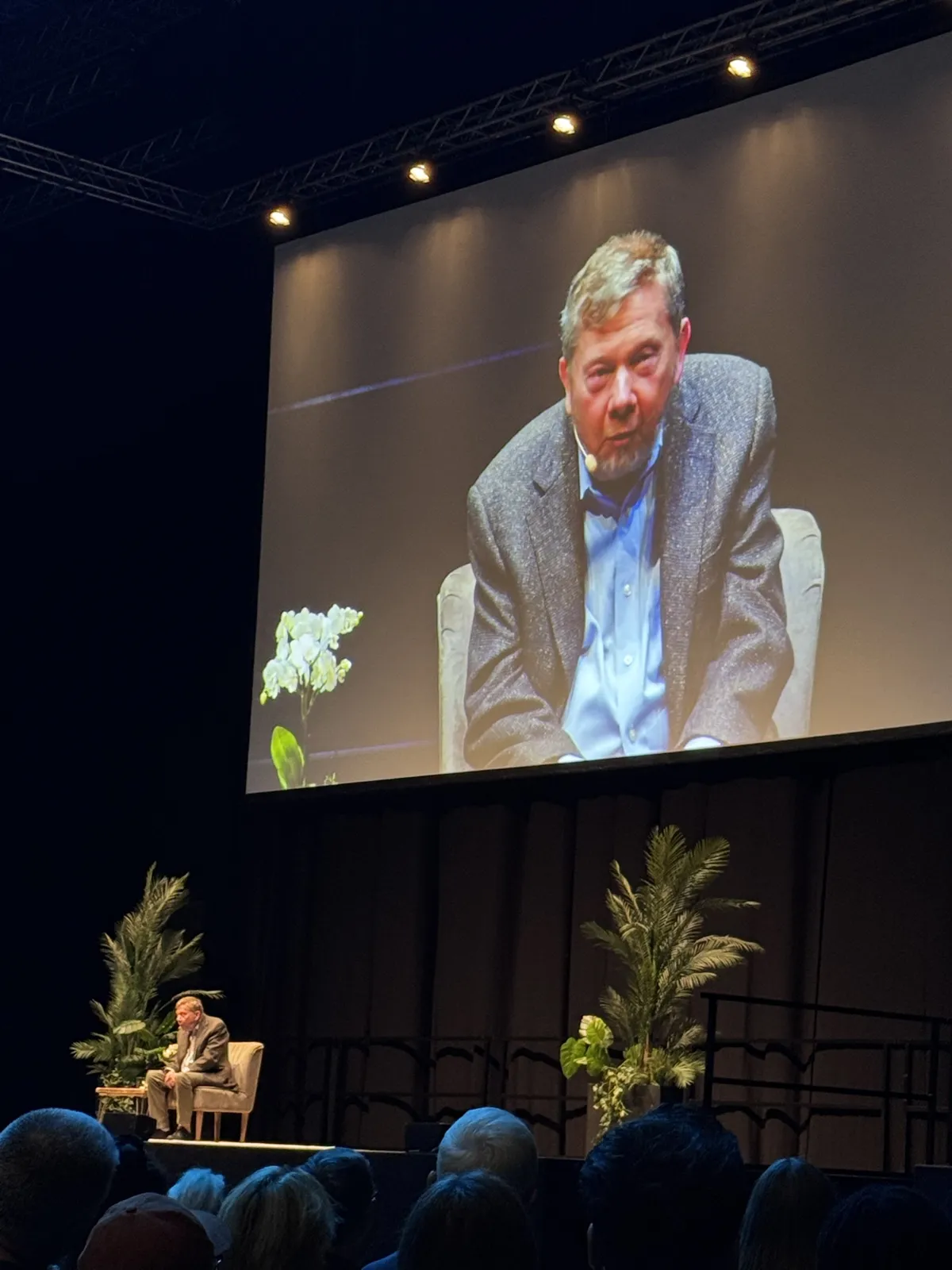 Eckhart Tolle on stage at the ExCeL, London, shown on the big screen above the audience