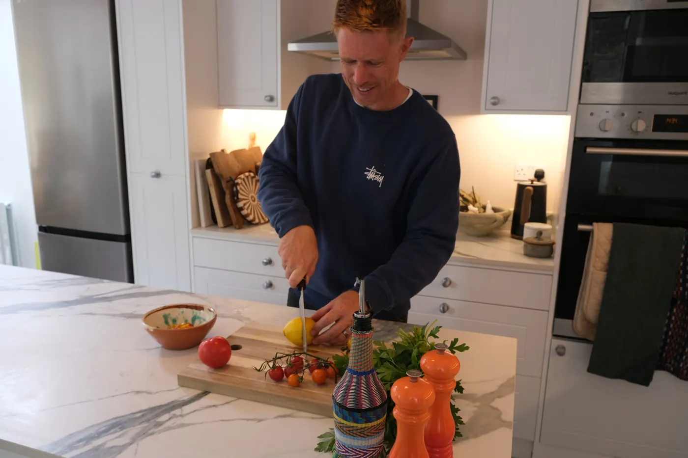 Mack Parnell chopping tomatoes and lemons in his kitchen